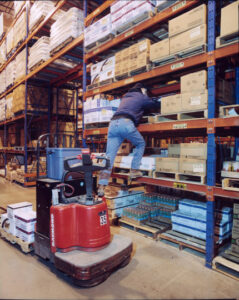 Employee climbing into a rack to collect items